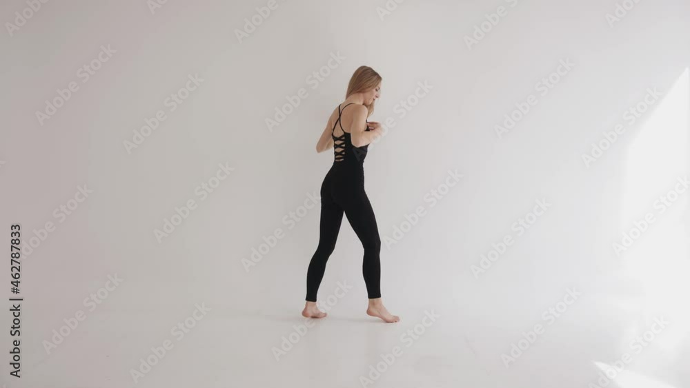 A slender young girl is engaged in barefoot stretching in the studio and rises on tiptoe. Harmony and balance concept A slender young girl is engaged in barefoot stretching in the studio and rises on tiptoe. Harmony and balance concept
