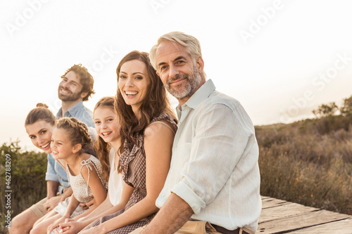 Large family enjoying the sunset sitting on a boardwalk
