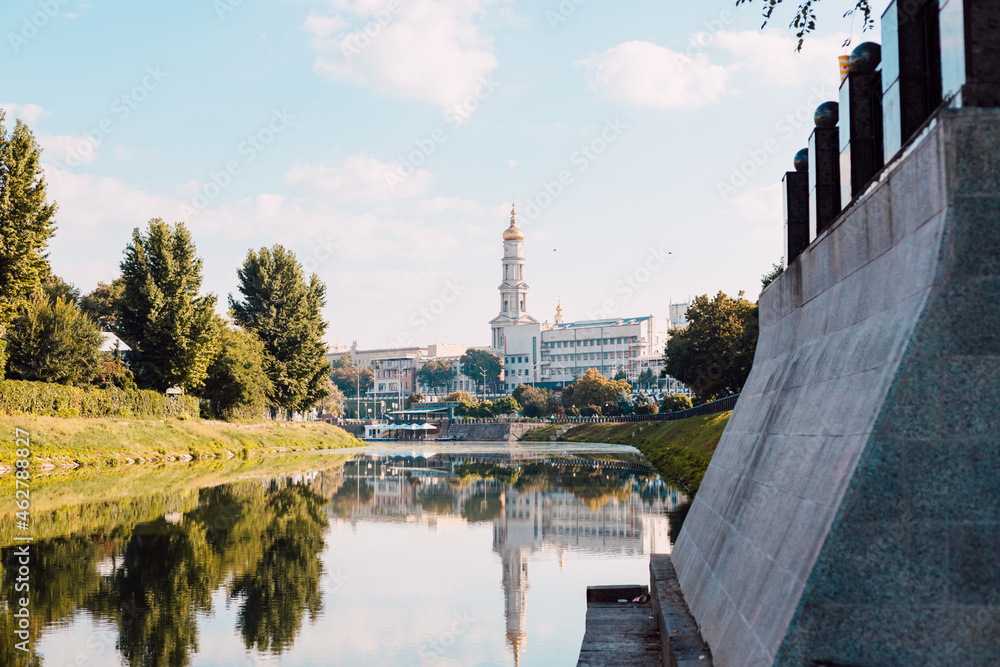 
Beautiful summer city embankment by the river in the city center with a view of the church