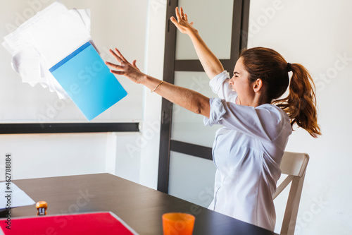 Angry female student at desk at home photo