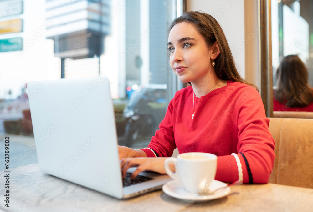 Young woman using laptop while sitting in cafe Young woman using laptop while sitting in cafe