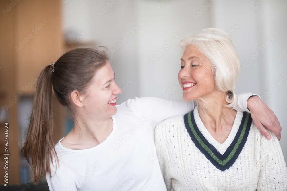 Smiling mother and adult daughter looking at each other Smiling mother and adult daughter looking at each other