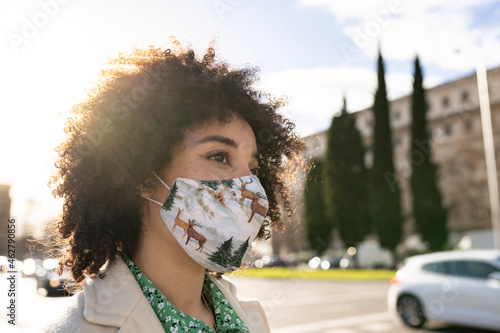 Afro woman with protective face mask in city during COVID-19 photo