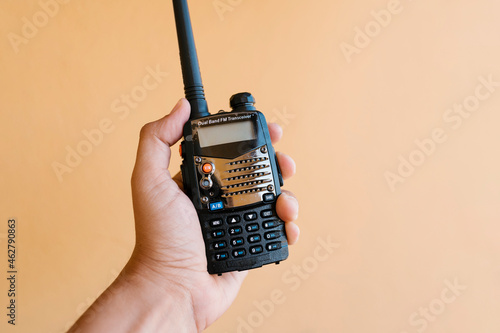 Hand holding walkie-talkie against wall