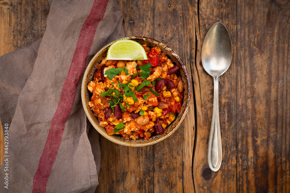 Bowl of vegetarian chili with tofu, corn, kidney and pinto beans, cilantro and lime Bowl of vegetarian chili with tofu, corn, kidney and pinto beans, cilantro and lime