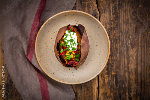 Sweet potato kumpir with chili con carne, sour cream and coriander photo