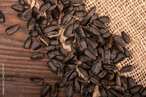 Fried black sunflower seeds scattered on the table, close-up, selective focus.