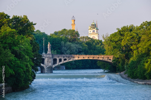 Germany, Upper Bavaria, Munich, Maximiliansbrucke crossing Isar river with Muffatwerk and Mullersches Volksbad towers in background photo