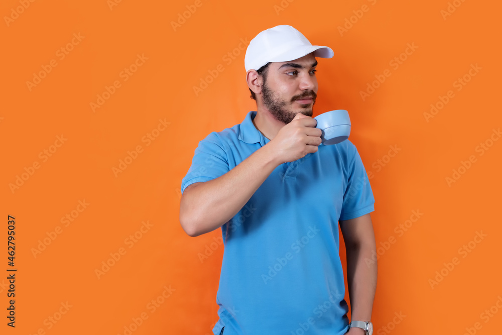 Man with cap and beard drinking hot coffee, on orange background. Man with cap and beard drinking hot coffee, on orange background.