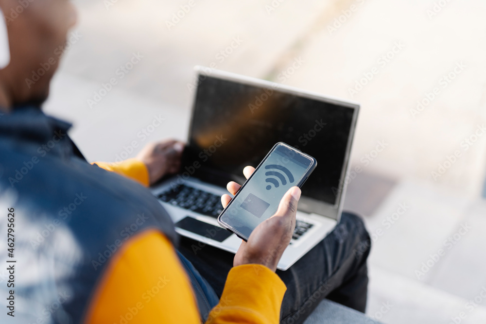 Close-up of man using laptop and smartphone for online shopping Close-up of man using laptop and smartphone for online shopping