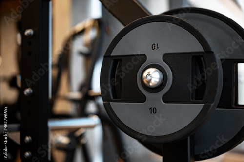 Weight plate on metal barbell in a gym