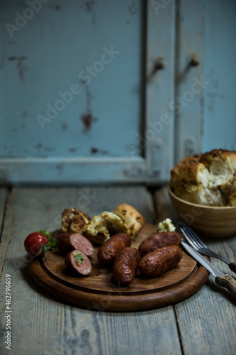 Fried salsiccia on cutting board with pickled bread photo