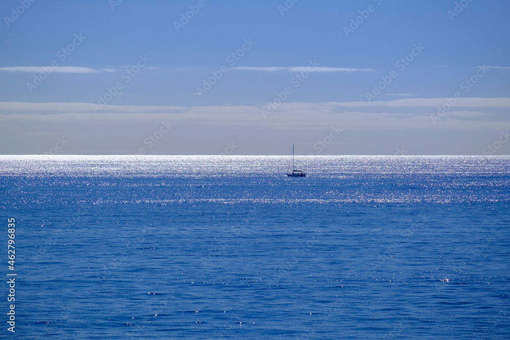 Spain, Lone sailboat traversing blue waters of Atlantic Ocean Spain, Lone sailboat traversing blue waters of Atlantic Ocean