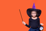Halloween time. Sullen disgruntled girl dressed as a fairy holding a black alarm clock and pointing to the copy space