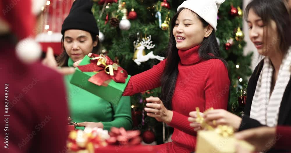 Young teens girls with family members sitting and help together to prepare wrap and stick ribbon on various kinds present boxes. Concept of love and relationship in Christmas festival Young teens girls with family members sitting and help together to prepare wrap and stick ribbon on various kinds present boxes. Concept of love and relationship in Christmas festival