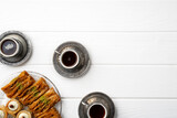 Top view of Turkish sweets and Turkish coffee on white wooden background