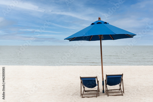 Blue beach chairs and umbrella with blue sky on the beach at tropical island.