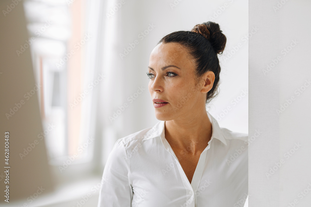 Close-up of thoughtful businesswoman standing by wall in home office Close-up of thoughtful businesswoman standing by wall in home office
