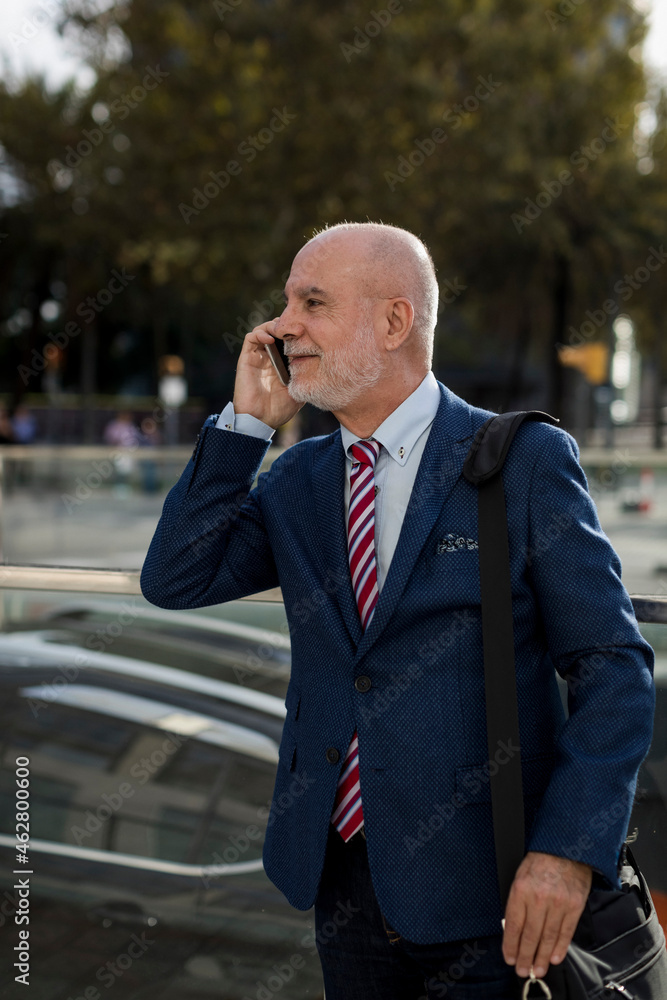 Senior businessman talking on cell phone in the city Senior businessman talking on cell phone in the city