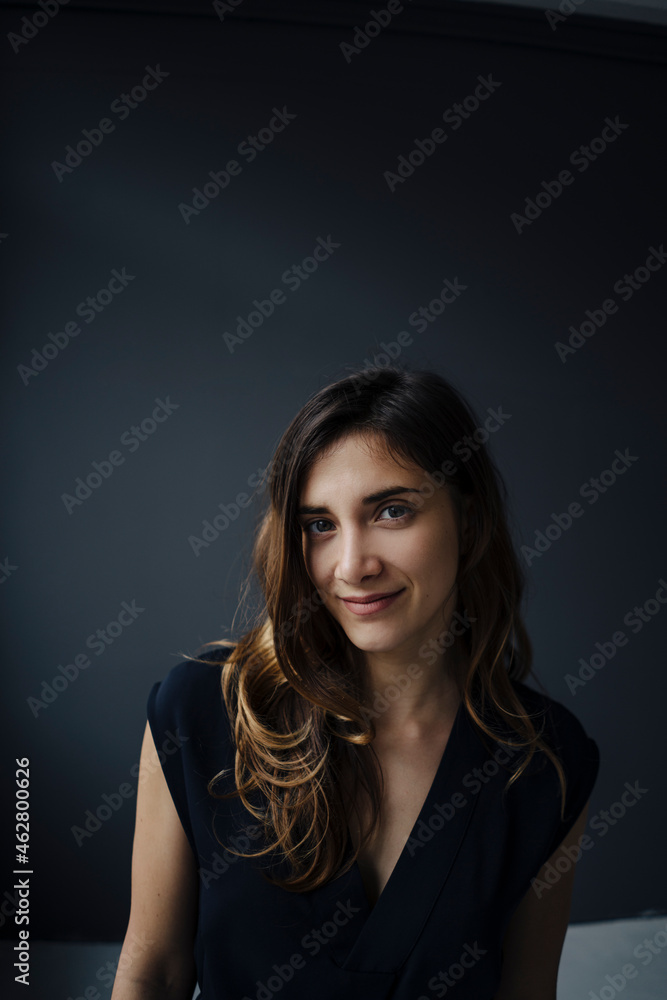 Portrait of smiling young woman against grey background Portrait of smiling young woman against grey background