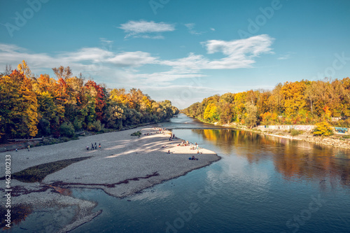 People relaxing at Isar river in Northern English Garden in autumn, Oberfohring, Munich, Germany