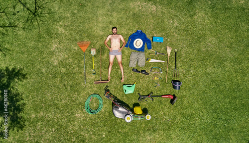 View from above of a gardener in laying on the grass with all the tools he need for take care of garden photo