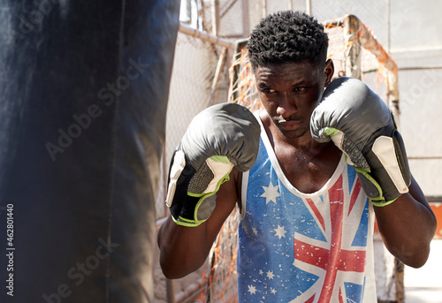 Boxer training with punching bag photo