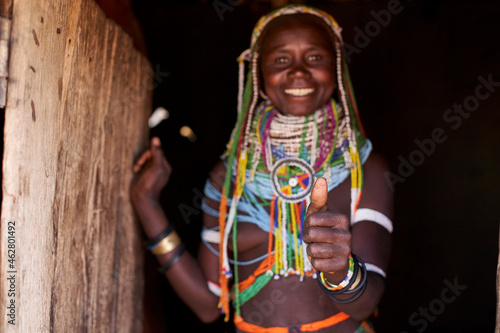 Portrait of a Muhila traditional woman standing in her house, giving humbs up, Congolo, Angola photo