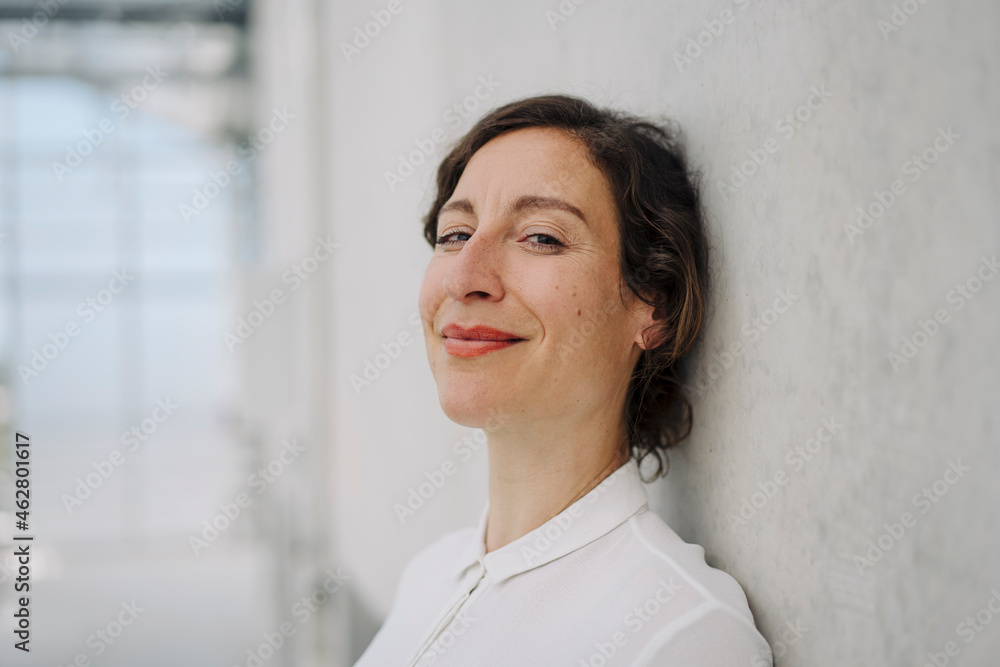 Portrait of a smiling businesswoman at a concrete wall Portrait of a smiling businesswoman at a concrete wall