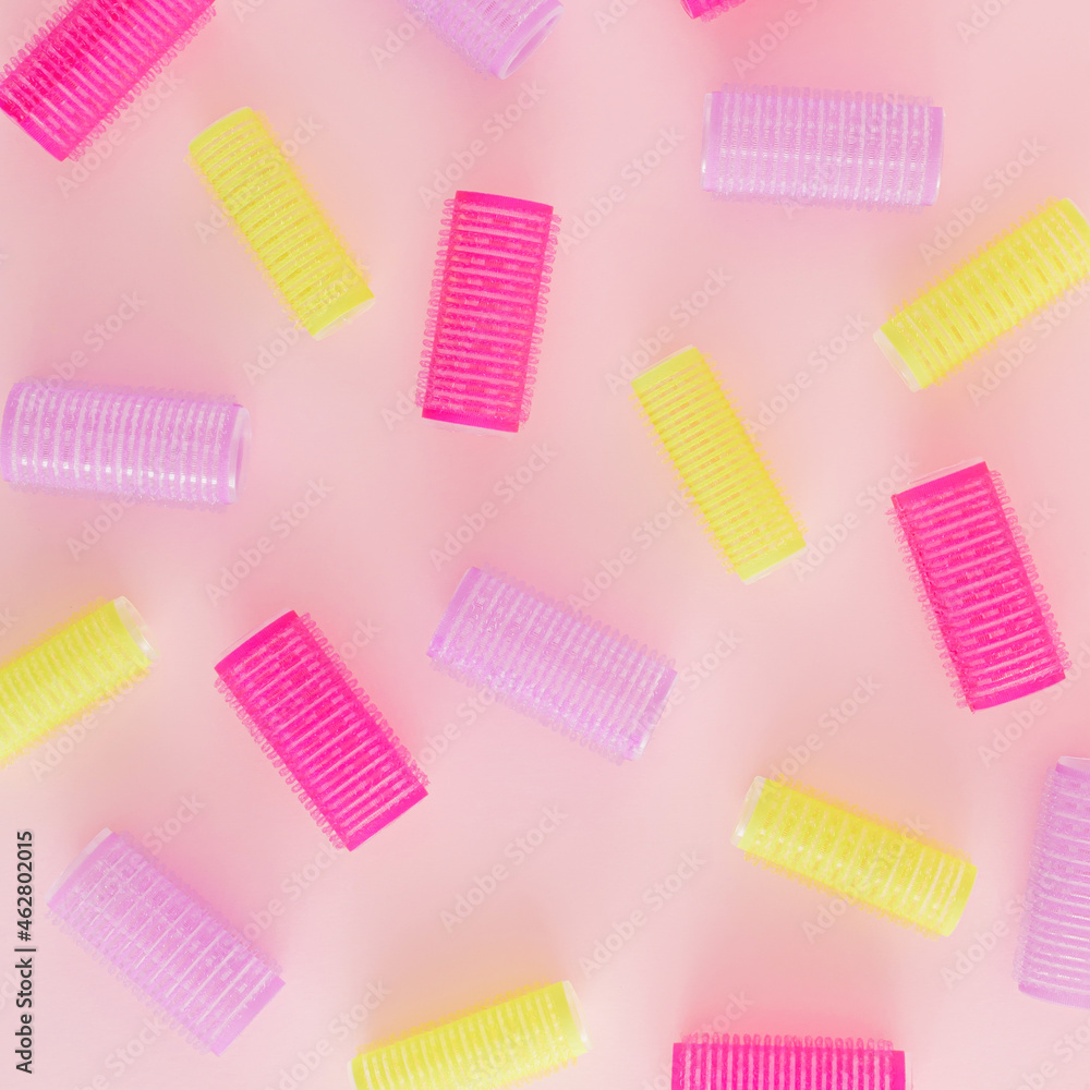 Creative pattern made of colorful hair curlers on a pastel pink background. Minimal retro fashion concept. Salons and hairstyle inspiration. Creative pattern made of colorful hair curlers on a pastel pink background. Minimal retro fashion concept. Salons and hairstyle inspiration.