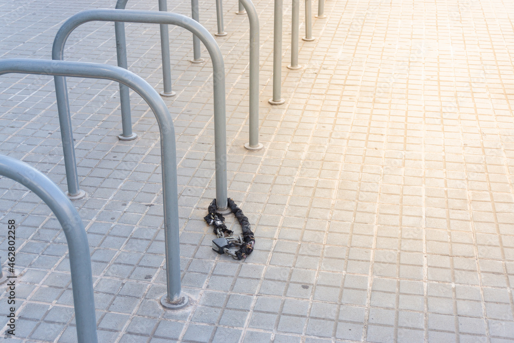 Abandoned padlock and chain in a public bicycle parking lot Abandoned padlock and chain in a public bicycle parking lot