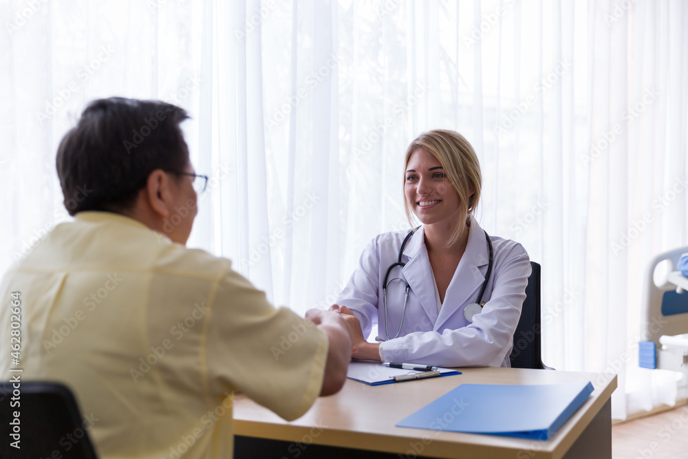 Female doctor discussing with senior male patient while sitting on the chair in the office at the hospital Female doctor discussing with senior male patient while sitting on the chair in the office at the hospital