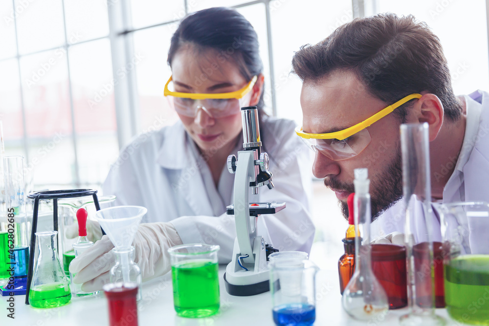Two scientists are researching and developing drugs for the treatment of diseases in the laboratory. Equipment,Scientific and healthcare concept. Two scientists are researching and developing drugs for the treatment of diseases in the laboratory. Equipment,Scientific and healthcare concept.