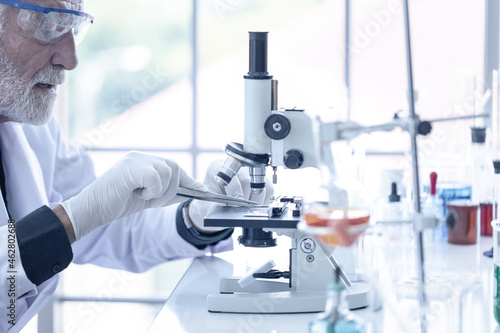 Senior scientist working with microscope in science laboratory, Searching for germs, viruses, disease, research and development, Scientific and medical