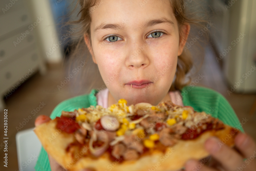 Cute girl with gray eyes eating slice of pizza at home Cute girl with gray eyes eating slice of pizza at home