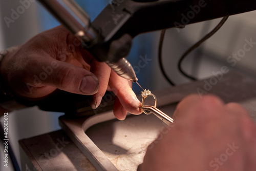 Man working in a welding a diamond ring with a welding machine