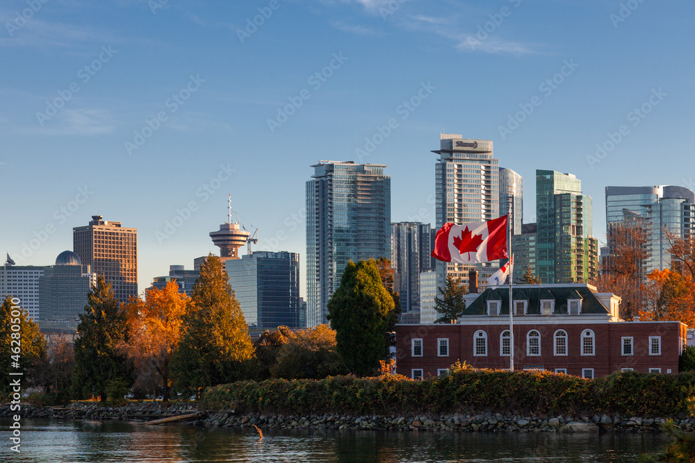 Obraz premium Downtown Vancouver modern Coal Harbor business district area high office and apartment buildings with Naval Museum with a large Canadian flag and fall foliage autumn
