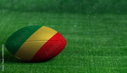 American football ball  with Congo Republic flag on green grass background  close up