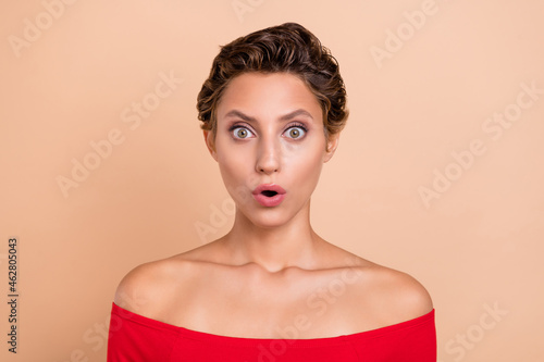 Photo of shocked astonished lady open mouth speechless face news reaction isolated on pastel beige color background