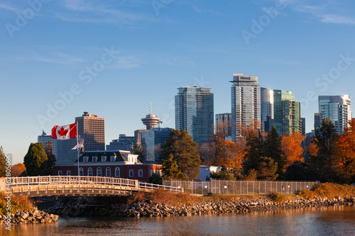 Downtown Vancouver modern Coal Harbor business district area high office and apartment buildings with Naval Museum with a large Canadian flag and fall foliage autumn