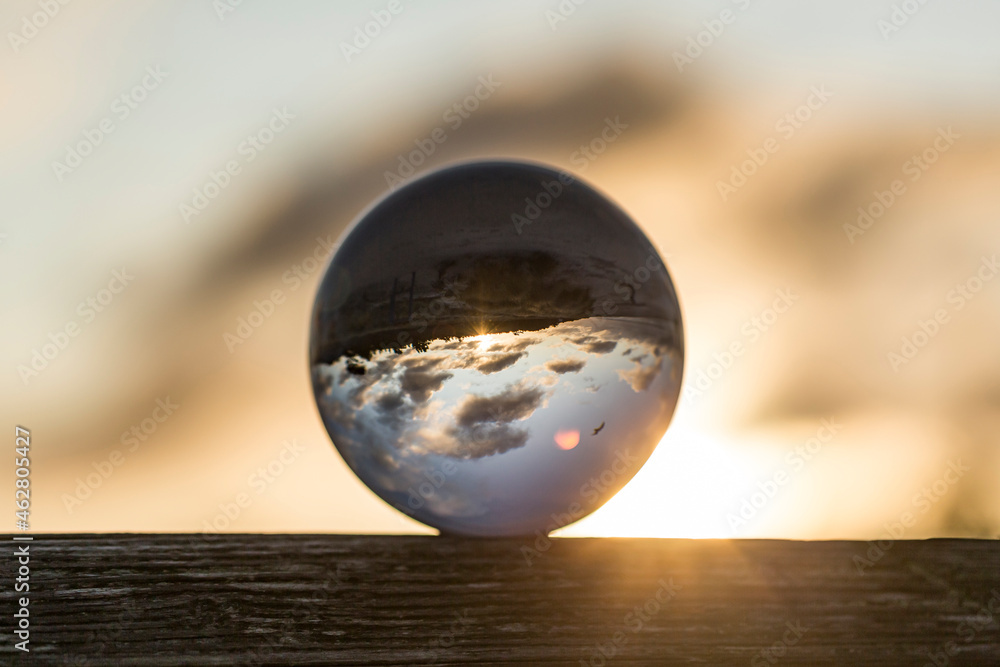 Germany, Mecklenburg-West Pomerania, Prerow, Shiny glass ball against rising sun Germany, Mecklenburg-West Pomerania, Prerow, Shiny glass ball against rising sun