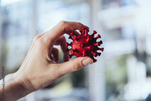 Hand holding model of corona virus, close up photo