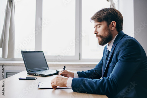 bearded man sitting at a desk in front of a laptop finance technologies