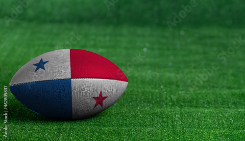 American football ball  with Panama flag on green grass background  close up