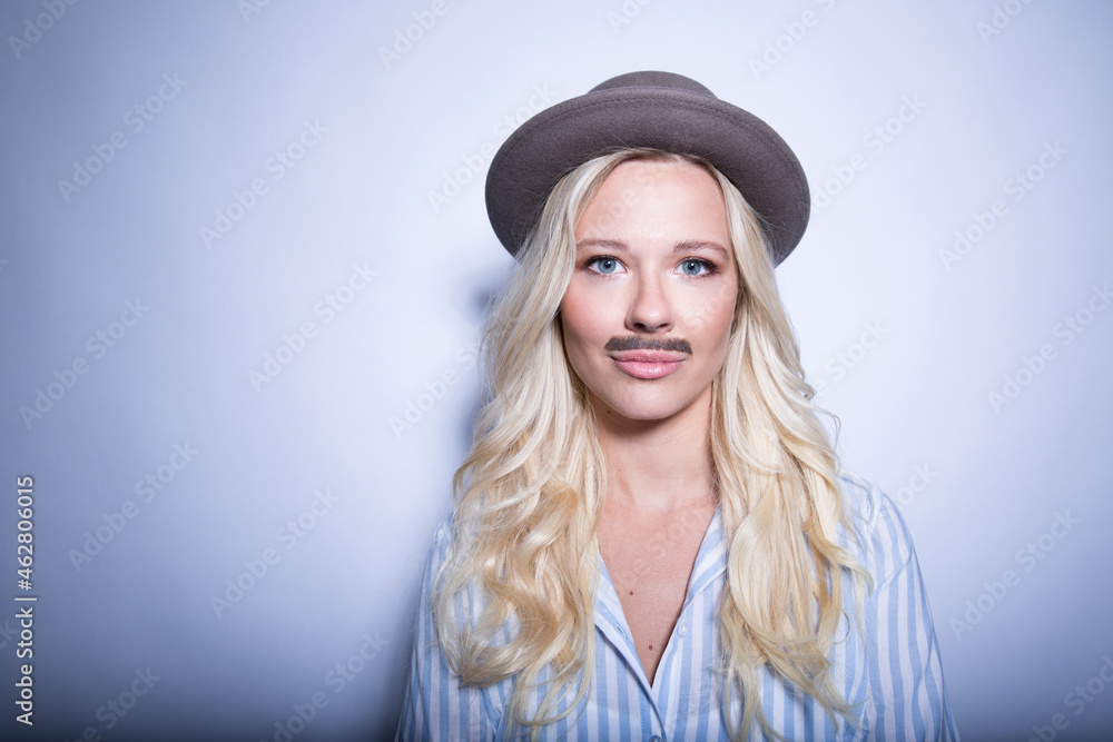 Portrait of blond young woman with fake moustache and hat Portrait of blond young woman with fake moustache and hat