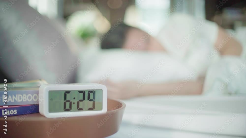 Alarm 6.29 to 6.30 in bedroom with the sleeping man on bed Alarm 6.29 to 6.30 in bedroom with the sleeping man on bed