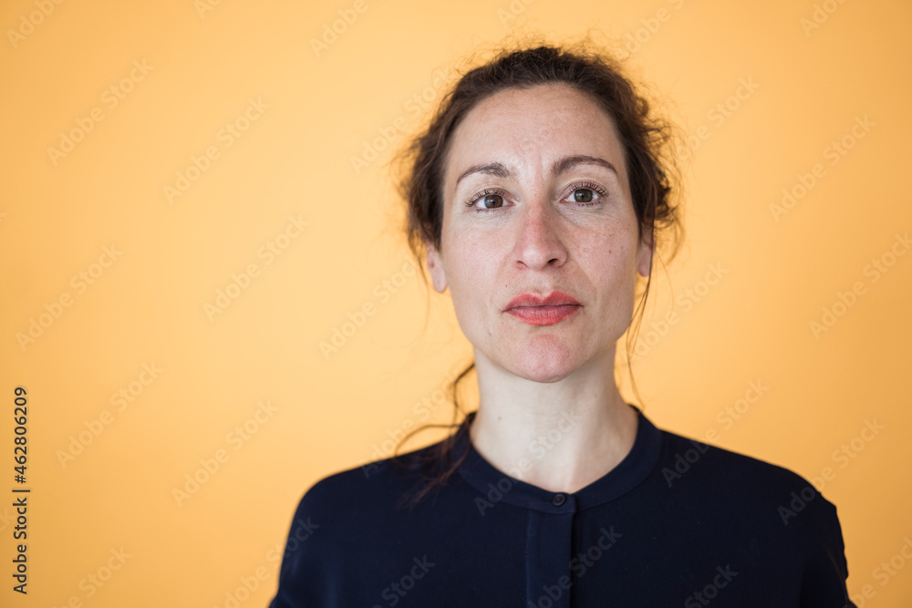 Close-up of female entrepreneur against orange wall Close-up of female entrepreneur against orange wall