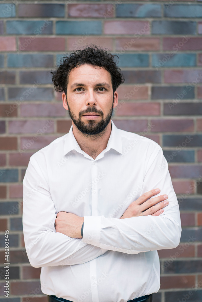 Male entrepreneur with arms crossed against wall Male entrepreneur with arms crossed against wall