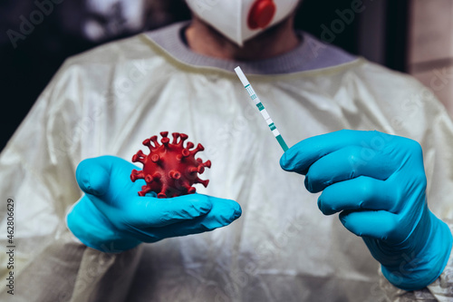 Healthcare worker holding model of Corona Virus and a lateral flow test