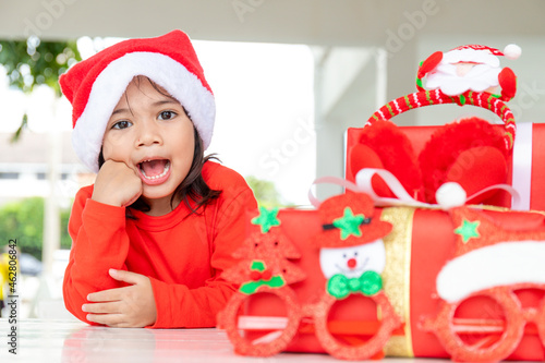 christmas, holidays and childhood concept - smiling girl with gift box at home